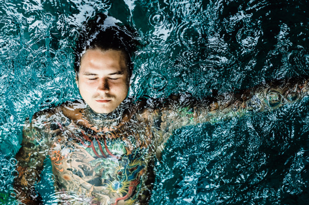 tattooed-man-in-the-pool-in-the-rain_1321-932
