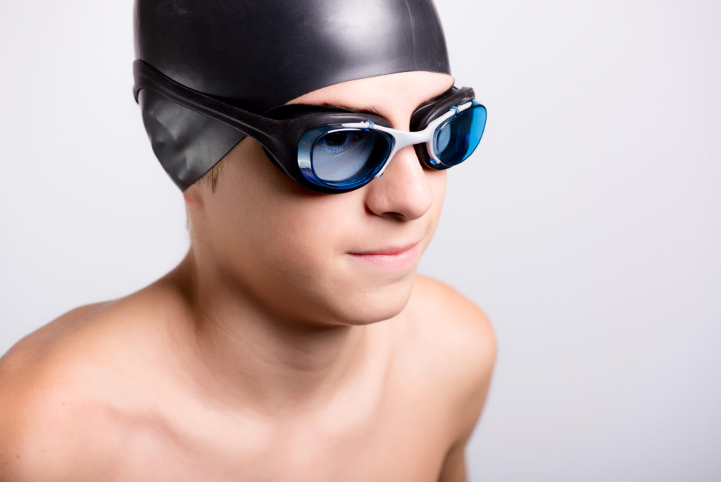 young athletic healthy teenager ready to swim with swimming goggles and cap